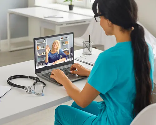 Nurse on laptop for healthcare consultation with employee